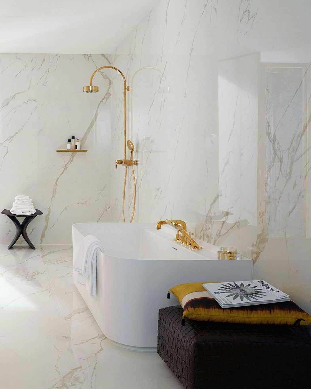 Casa de banho luxuosa com torneiras de duche e banheira em dourado AXOR Citterio
