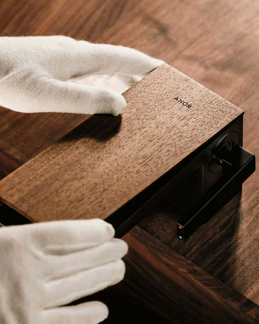 Colocação da placa com padrão madeira em torneira de lavatório em preto AXOR MyEdition