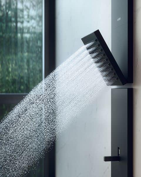 Pormenor de água a correr do componente chuveiro de ombro, incluido no painel de duche Axor ShowerComposition na cor preto.